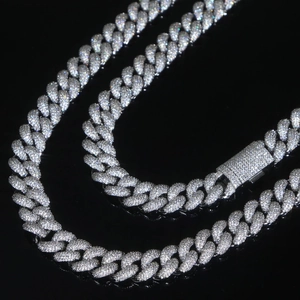 Macro shot of 15mm silver iced out Cuban chain with sparkling crystals on a black surface
