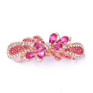 Macro shot of rose gold butterfly hair clip with pink pear-shaped crystals on white background