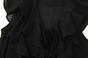 Close-up of ruffled V-neckline with delicate ties on black chiffon boho style top