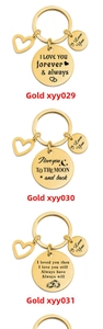 Detailed close-up of three gold-plated stainless steel keychains with heart charms