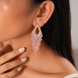 Close-up of pink crystal fringe earrings with gold-tone geometric rectangle stones