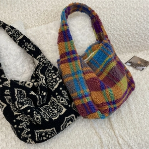 Detail of plush lamb wool tote bags featuring geometric ethnic patterns and colorful plaid