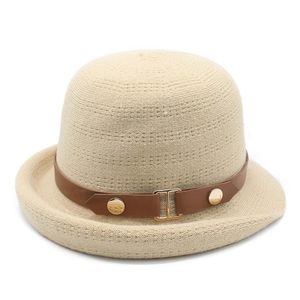 Détail du chapeau tricoté beige avec bandeau en cuir brun et boucle H dorée