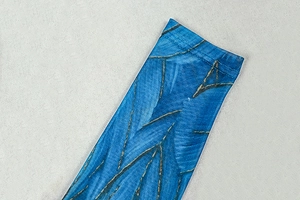 Detail of blue mesh fabric with golden geometric patterns and reinforced stitching