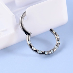Detail of G23 titanium nose ring featuring teardrop opal stones on a white stand