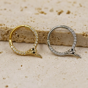 Detailed view of gold and silver snake nose rings with sparkling pave crystals
