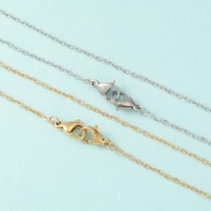Macro view of gold and silver stainless steel chain with secure lobster clasp closures