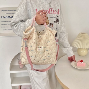 Quilted beige canvas bag featuring bear and strawberry prints with colorful woven handle