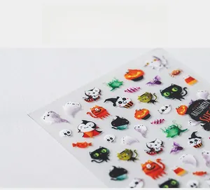 Macro shot of 5D Halloween nail stickers featuring cute ghosts, pumpkins and candy