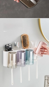 Macro detail of wall-mounted toothbrush holder with four colorful transparent rinsing cups