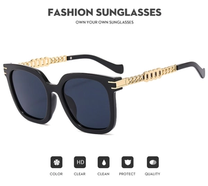 Detailed view of fashion sunglasses featuring black frames and elegant gold metal temples