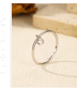 Detail of S925 sterling silver ring with a dangling round D-color moissanite stone