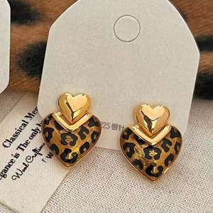 Detail of leopard print double heart earrings with gold metal frame and 925 silver needles
