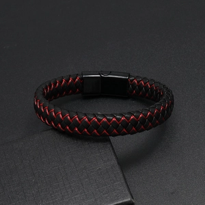 Dettaglio del bracciale in pelle intrecciata rossa e nera con chiusura magnetica nera