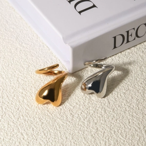 Macro view of gold and silver heart-shaped stainless steel wrap rings on book