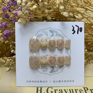 Detailed view of handmade baroque pearl press-on nails with gold chain and floral accents