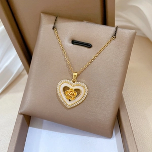 Detailed view of a gold heart pendant featuring a 3D rose and sparkling crystals in a box