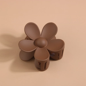 Détail d'une pince à cheveux fleur marron mat avec ressort durable et cinq pétales ronds