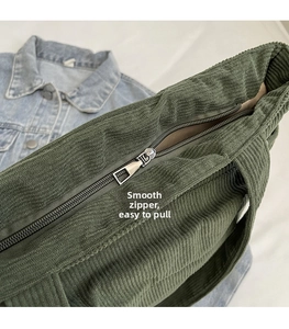 Détail macro de la fermeture éclair fluide sur ce sac cabas en velours côtelé vert