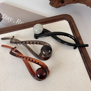 Three vintage resin hair claws in black and brown tones with elegant ball ornament details