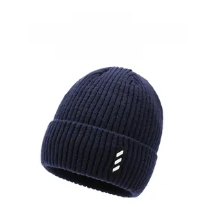 Close-up of navy blue ribbed knit hat showing thick texture and striped brand label