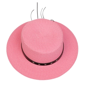 Detail of pink straw hat featuring black band with silver star rivets on a white background
