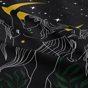Macro detail of bohemian tapestry showing moon and leaf prints on soft black fabric
