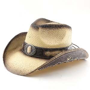 Detail of western straw cowboy hat with vintage turquoise buckle and burnt edge finish