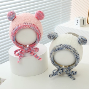 Plush baby winter hat with double pom-poms and warm ear flaps in pink and white