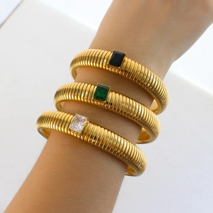 Three-piece gold threaded bracelets set with black, green, and clear rectangular crystals