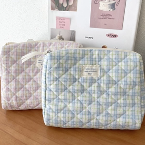 Detailed view of quilted makeup bags with rhombus patterns and fabled brand woven label