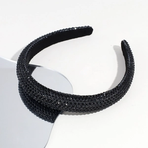 Detail shot of black rhinestone headband with dense crystal embellishments and velvet base