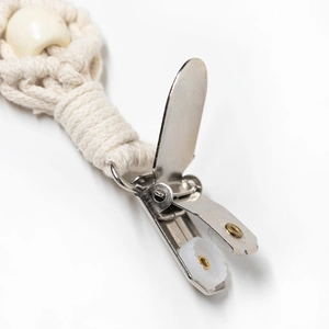Close-up of baby pacifier clip featuring cotton braided cord and a smooth wooden bead