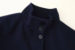 Detail einer marineblauen Wolljacke mit Stehkragen und drei schwarzen Knöpfen