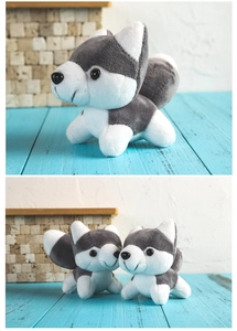 Close-up of soft grey and white husky plush toy with cute round design on blue wood desk