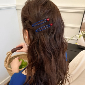 Navy blue U-shaped hair clips with red heart charm accents for women on wavy hair