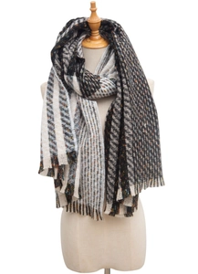 Detailed view of the black and white striped woven texture and fringe of the winter scarf
