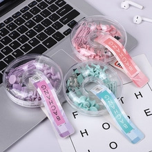 Detailed view of pastel macaron stationery sets with clips and pins on a laptop