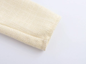 Détail de la manche d'une robe en tweed blanc cassé avec des textures de fils argentés