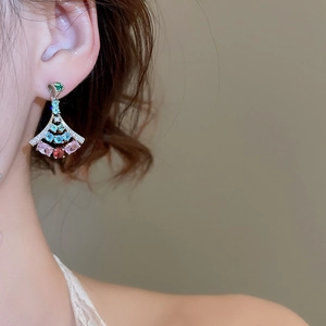 Macro shot of silver fan-shaped earrings with colorful pave zircon stones on model