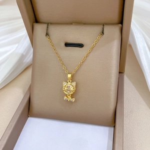 Detail of gold cat pendant with pavé crystals on a satin jewelry display