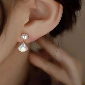 Detail of fan-shaped baroque pearl drop earrings with mother of pearl in gold finish