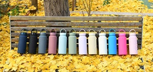 Outdoor view of large stainless steel sports water bottles in twelve matte colors on a bench