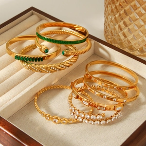 Golden stainless steel bracelet set with green zircon stones and spiral twist designs