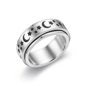 Polished stainless steel spinner ring with black star and moon patterns on white background