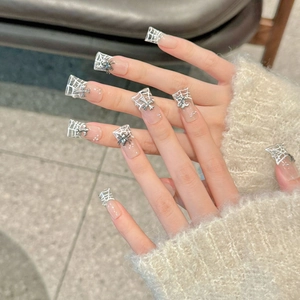 Gothic press-on nails with white spider web art, silver charms and pearl accents
