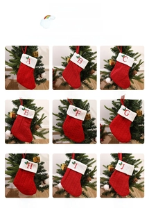 Close-up of red knit Christmas stockings with white cuffs and embroidered letters