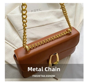 Detailed shot of brown leather bag with chunky gold chain strap and geometric buckle