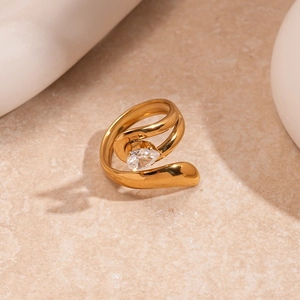 Macro view of water-drop zircon and golden irregular open ring on stone surface