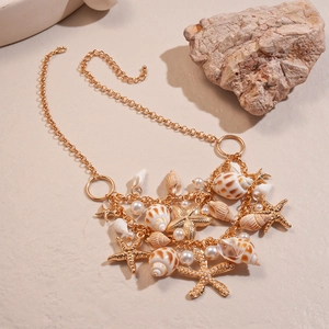 Detail of double-layer necklace with golden starfish, shells and faux pearls pendants